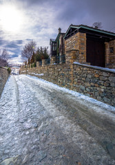 View of traditional stone buildings and streets with snow at the famous village of Nymfaio near Florina, Greece. 