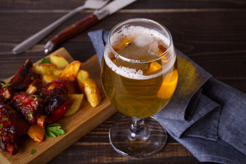 Beer and pork spare ribs with fry. Beer and meat. Glass of ale. horizontal