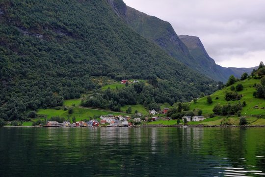 Holy grail illustrated from Sognefjord or Sognefjorden created from mountain range with blue sky and reflection in clear water and having a wooden dock point out in a river in Fl&aring;m