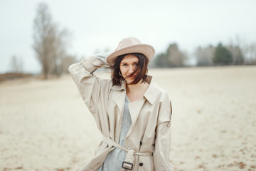 Portrait of a young attractive girl in a stylish cloak and hat.