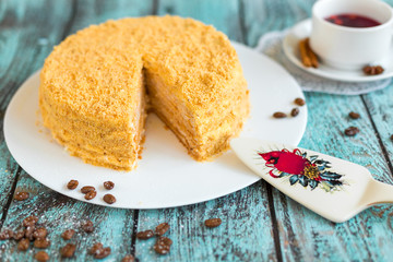 Honey cake on white plate on wooden table. Picture for a menu or a confectionery catalog