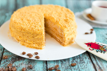 Honey cake on white plate on wooden table. Picture for a menu or a confectionery catalog