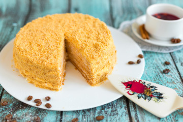 Honey cake on white plate on wooden table. Picture for a menu or a confectionery catalog