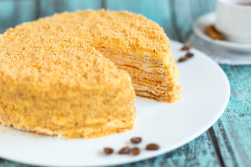Honey cake on white plate on wooden table. Picture for a menu or a confectionery catalog