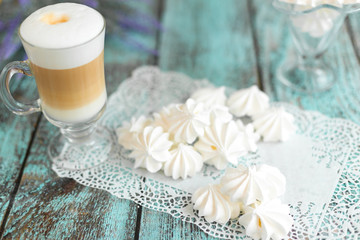 White marshmallows and bizet with coffee latte on the table in cafe. Delicious sugar dessert. Food photo concept