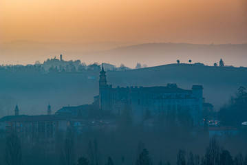 Castle of Costigliole d'Asti, Langeh and Monferrato region, Piedmont, Italy. Sunset time with foggy light