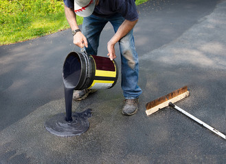 Pouring asphalt onto driveway for resealing
