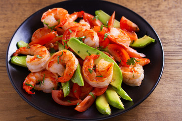 Shrimp, Avocado, Tomato and Cilantro Salad. Grilled prawns on black plate