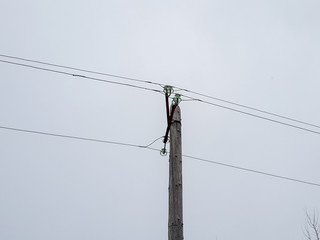 A pole with electrical wires. Wooden pole holding live wires