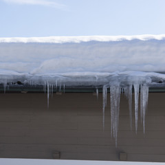 Eiszapfen am Hausdach im Winter