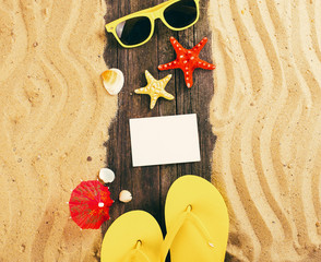 flip flop and sunglasses on sandy pier near ocean