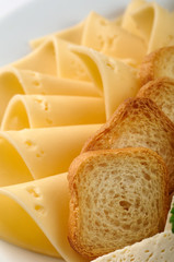 Fresh bread and various types of expensive Swiss, Dutch, Italian, French cheese. Bread and cheese basket for a party, buffet, festive table. Appetizer in light yellow tones.