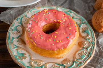 Pink donut lying on a designer plate.