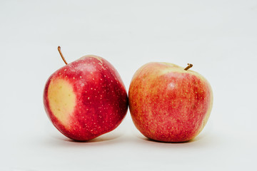 Two fresh red apples isolated on white. Delicious apples lie on the table. The concept of providing vitamins along with fruits. Eating fruit on a daily basis.