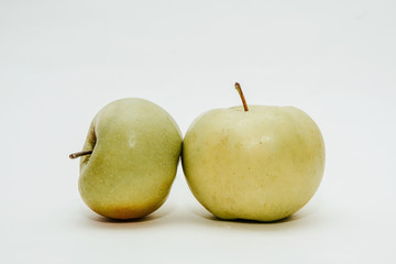 Two fresh green apples isolated on white. Delicious apples lie on the table. The concept of providing vitamins along with fruits. Eating fruit on a daily basis.