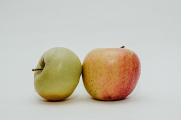 Two fresh red apples isolated on white. Delicious apples lie on the table. The concept of providing vitamins along with fruits. Eating fruit on a daily basis.