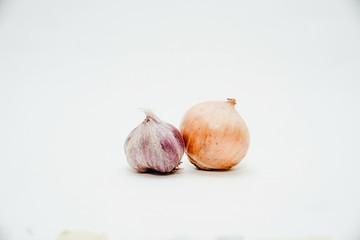 Onions and garlic isolated on a white background. The concept of using vegetables for preparing meals. Using onions to eat. The concept of adding spices for taste.