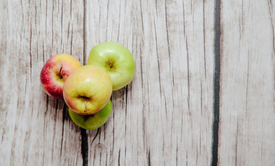 Fresh red and green apples on wooden. Delicious apples lie on the table. The concept of providing vitamins along with fruits. Eating fruit on a daily basis.