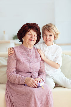 portrait of beautiful mature woman (80 years old) with her great-grandson at home
