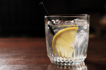 alcoholic drink with lemon and ice on a old wooden table