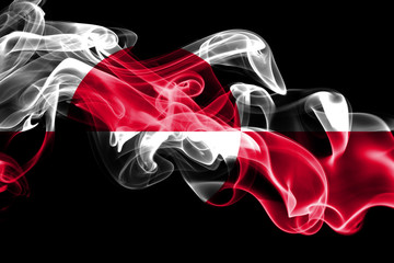 Fototapeta premium National flag of Greenland made from colored smoke isolated on black background. Abstract silky wave background.