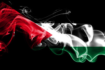 National flag of Jordan made from colored smoke isolated on black background. Abstract silky wave background.