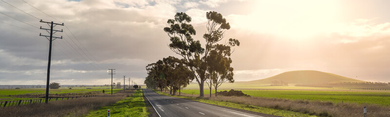 Panoramic view of a lonely country road with late afternoon sun in Victoria Australia