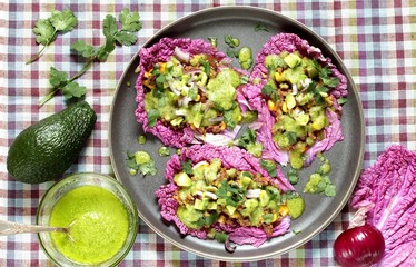 keto diet taco food is wrapped instead of cakes in cabbage leaf of Peking cabbage with avocado mayo with avocado, ground beef, onions, corn and cilantro, healthy fats without carbohydrates.