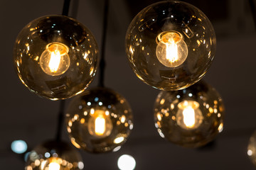 many burning incandescent bulbs hanging on the ceiling