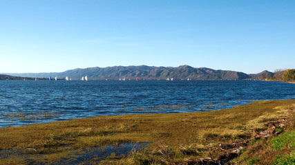 Fototapeta na wymiar Sailboats in San Roque Lake, Villa Carlos Paz, Cordoba, Argentina.