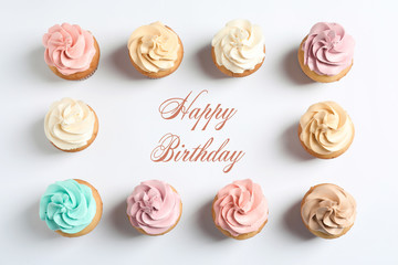 Flat lay composition with delicious birthday cupcakes and space for text on white background