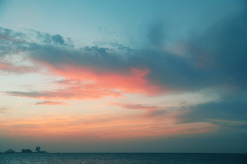 Fototapeta na wymiar Beautiful view of sea, distant city on shore and amazing sunset sky