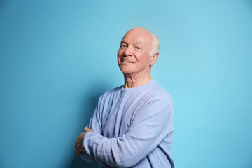 Portrait of elderly man on color background