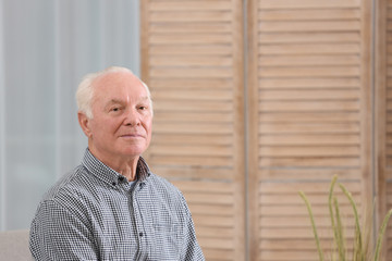 Portrait of elderly man at home. Space for text