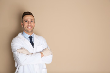 Portrait of male dentist on color background. Space for text