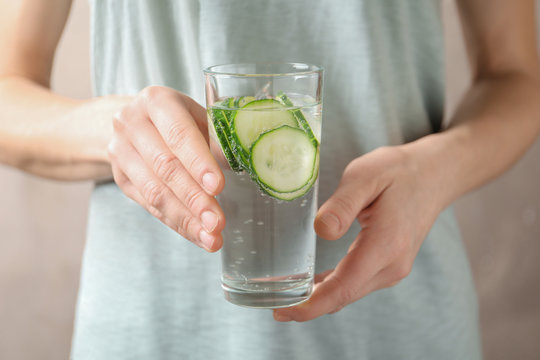 Young Woman Holding Glass With Fresh Cucumber Water, Closeup