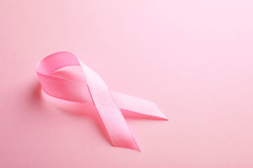 Pink ribbon on color background, space for text. Breast cancer awareness concept