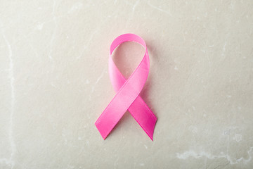 Pink ribbon on grey background, top view. Breast cancer awareness concept