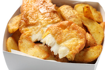 Disposable container with British Traditional Fish and potato chips on white background, closeup