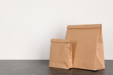 Paper bags on table against white wall. Mockup for design