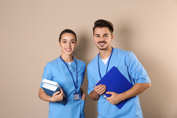 Happy young medical students on color background