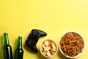 Flat lay composition with video game controller, snacks and space for text on color background © New Africa