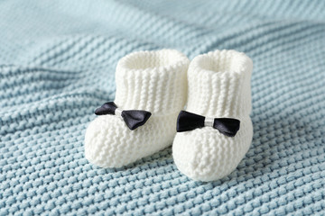 Fototapeta na wymiar Handmade baby booties on soft knitted plaid