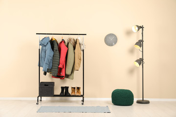 Stylish hallway interior with clothes on hanger stand