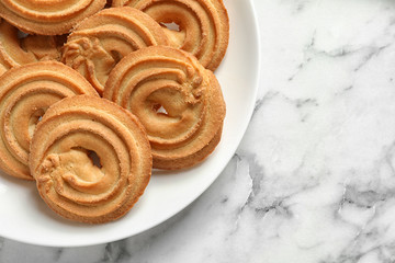 Plate with Danish butter cookies on marble table, top view. Space for text