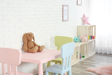 Cozy kids room interior with table, chairs and toys