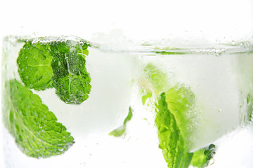 Drink with mint and ice cubes in glass on white background, closeup