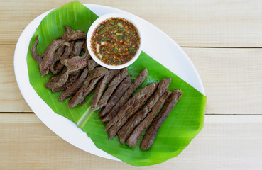 Barbecue Thai food style in a white dish on wood floor table, Ingredients for cooking, Top view.