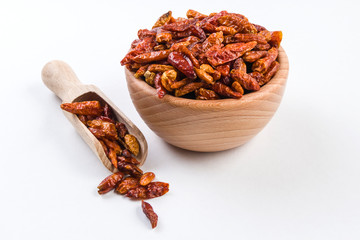 piri piri pepper in wooden bowl and scoop isolated on white background. Closeup.
