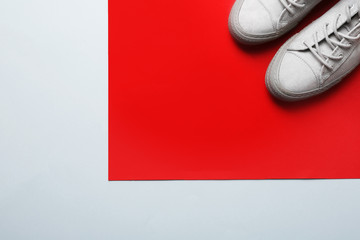 Stylish sneakers on color background, top view with space for text